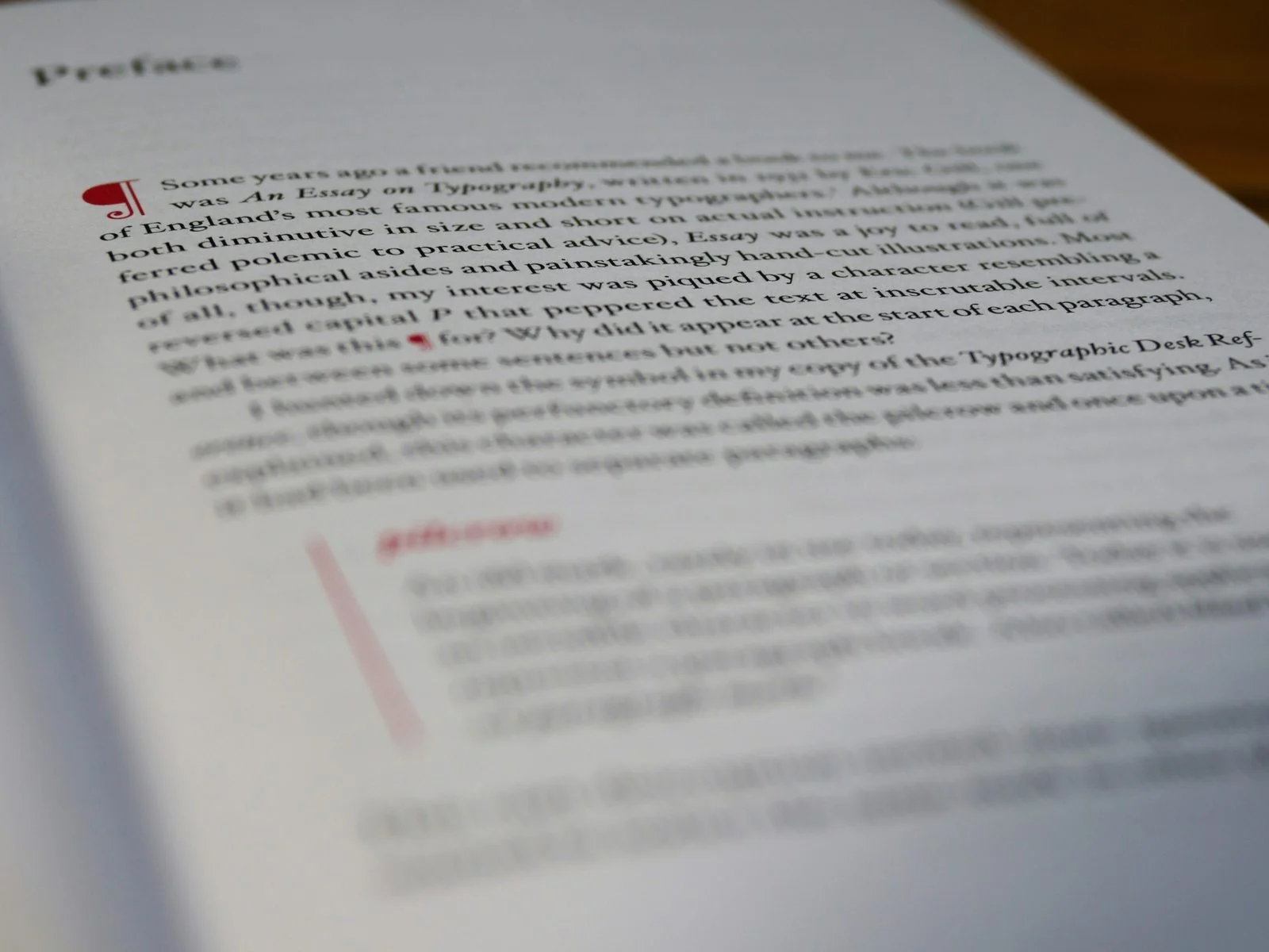 Open reference book with annotated text and a red pilcrow mark.